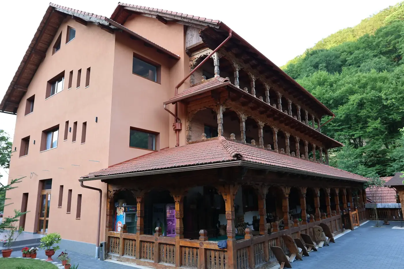 Fațada Pensiunii Casa Suciu pe trei niveluri, cu pridvoare din lemn sculptat