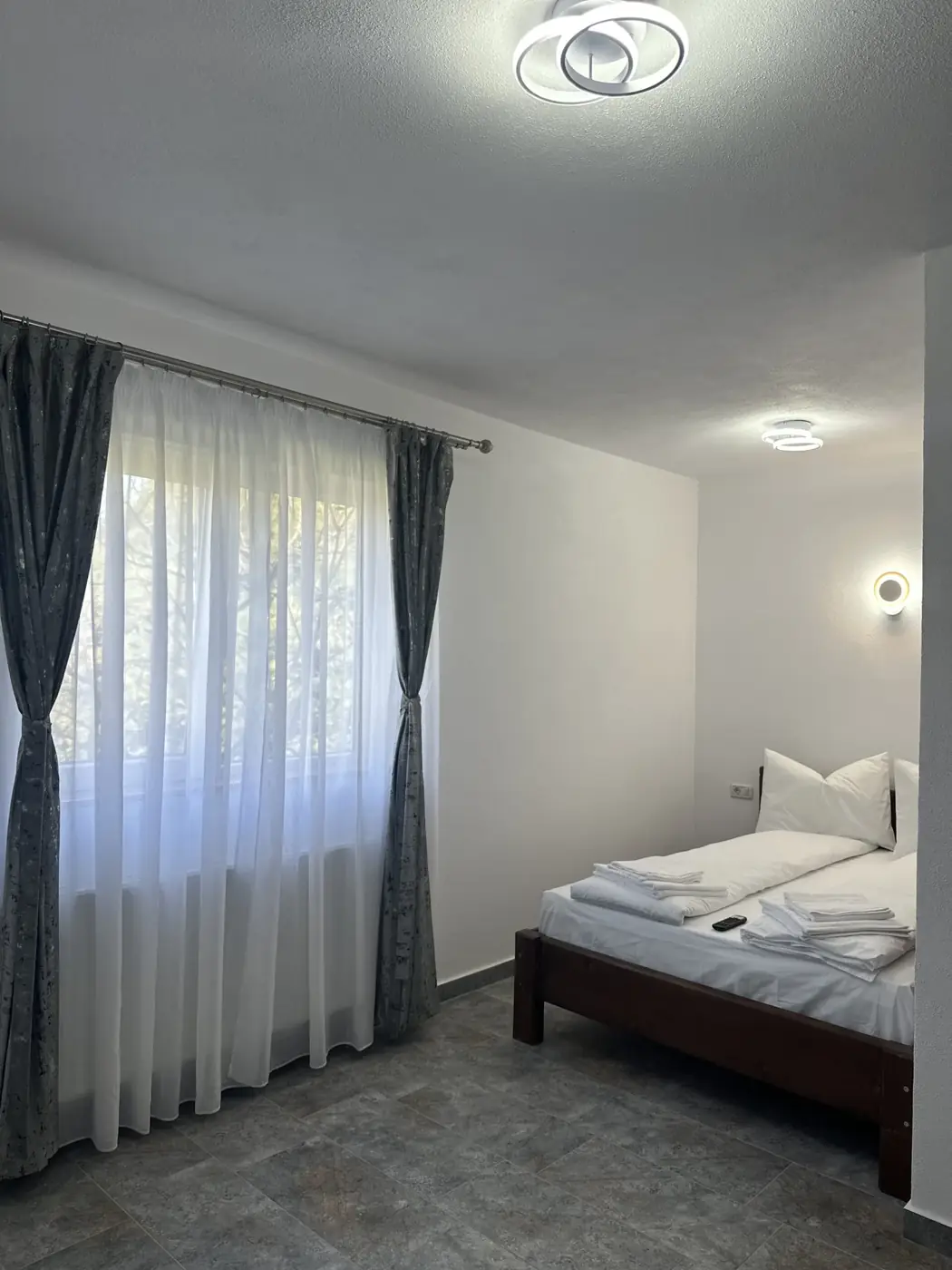 Pat dublu cu lenjerie albă într-o cameră la Casa Suciu