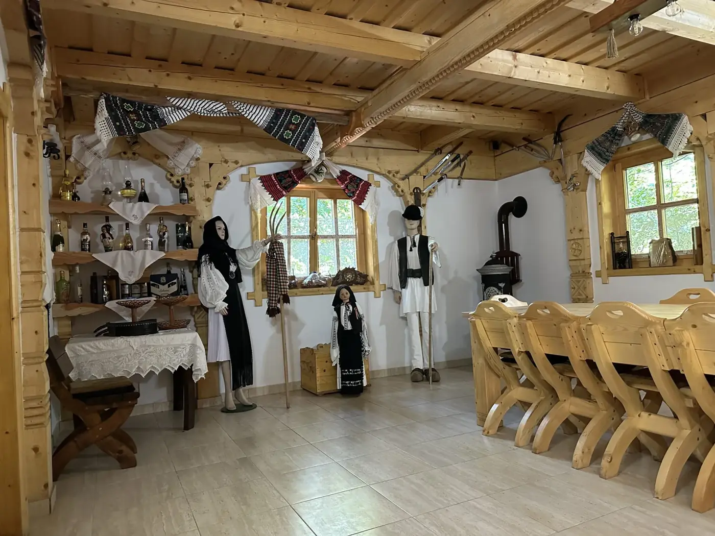 Sală de evenimente cu mese lungi și decor tradițional la Casa Suciu