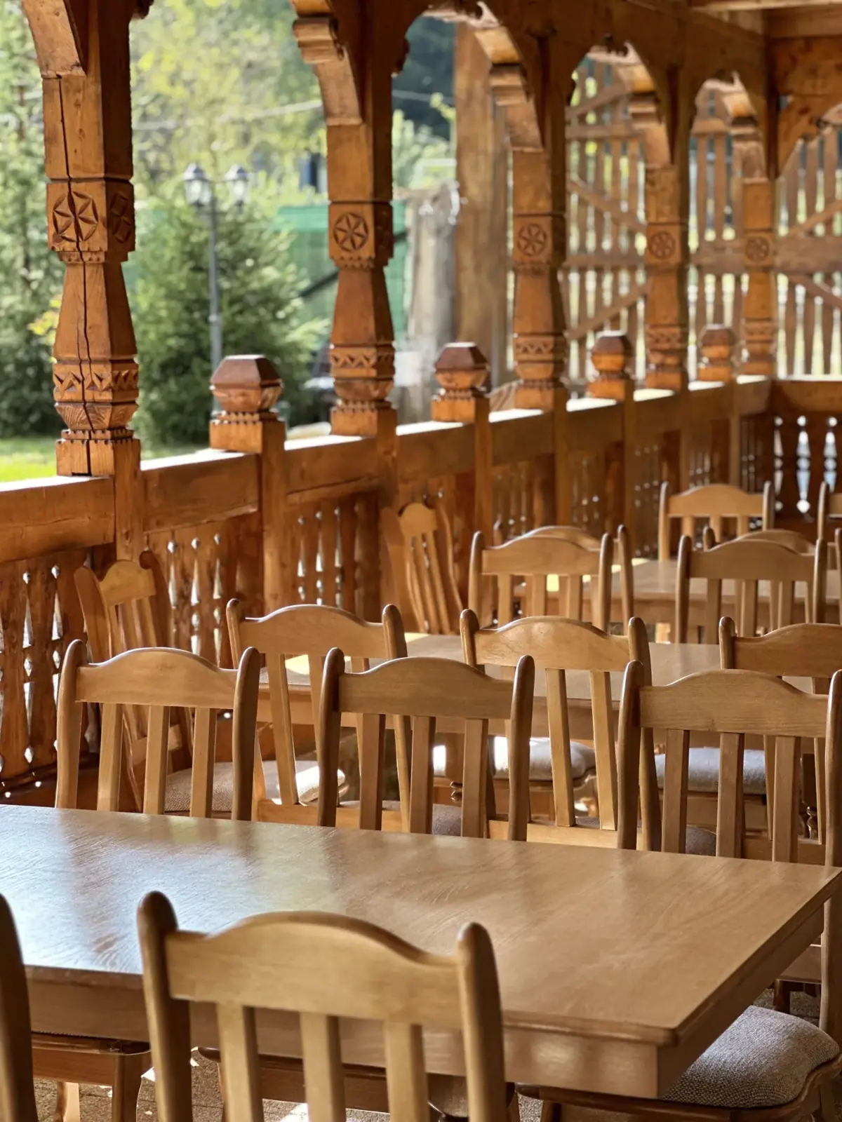 Restaurant tradițional cu mese lungi de lemn la Casa Suciu