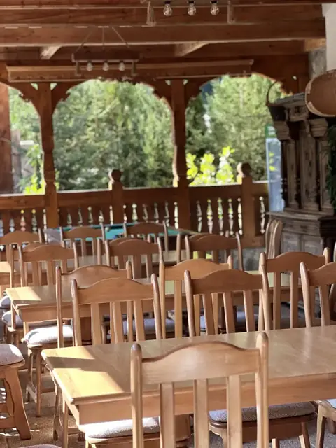 Pridvor din lemn sculptat cu vedere la pădure, Pensiunea Casa Suciu