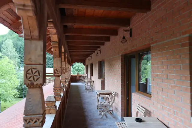 Balconul lung de la etaj cu stâlpi sculptați, Pensiunea Casa Suciu