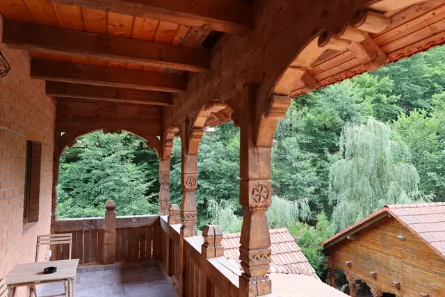 Balconul din lemn sculptat al camerei duble cu vedere la Munții Șureanu